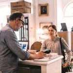 Owner using card reader in front of female customer at shop counter